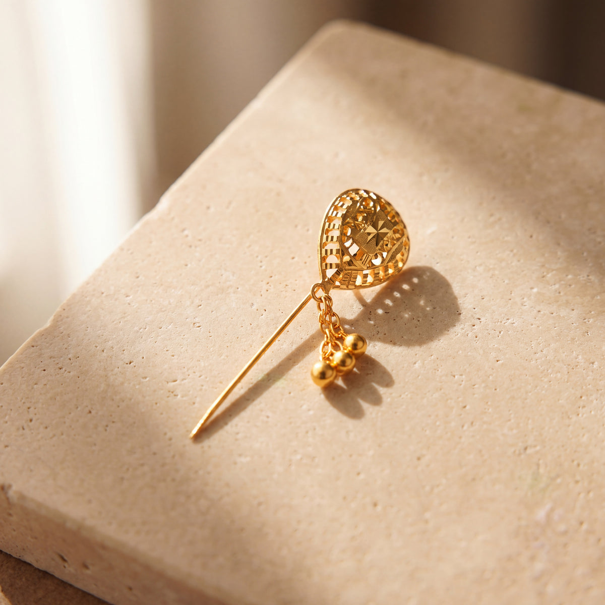 Daboos (D38) scarf pin on travertine stone
