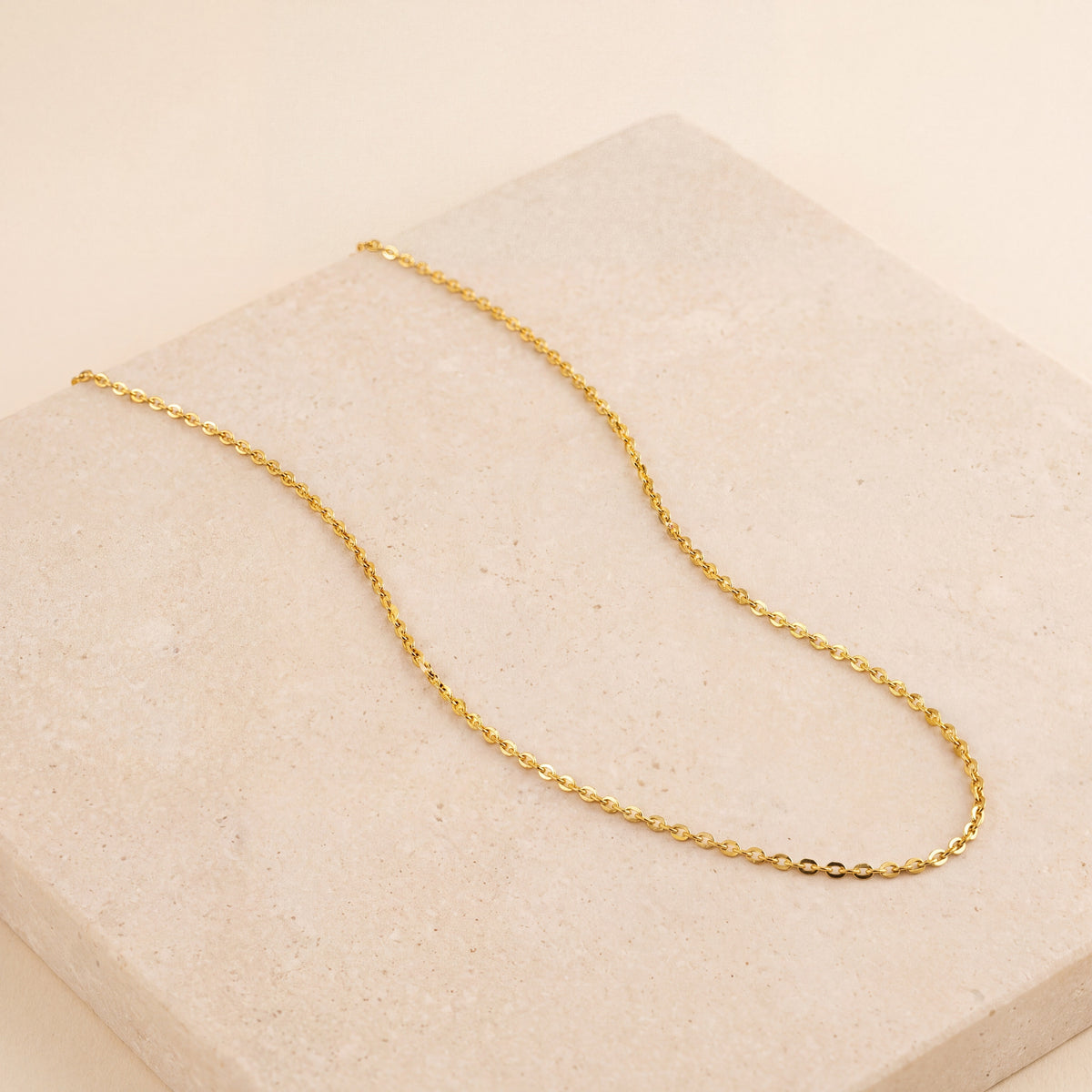 Diamond Cut Square Link Chain laid flat on travertine