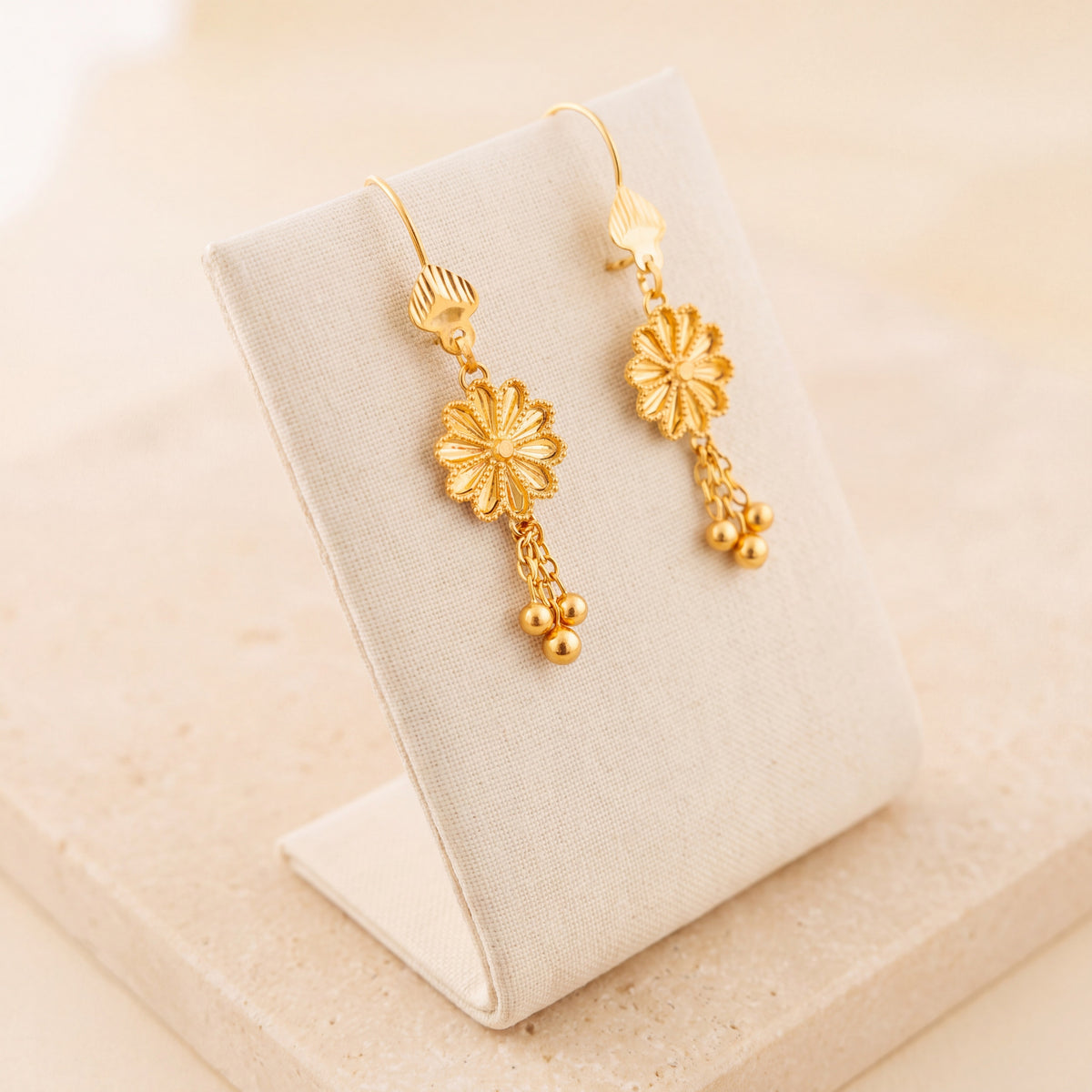 Flower Earrings 3 – Gold flower with dangles, on travertine