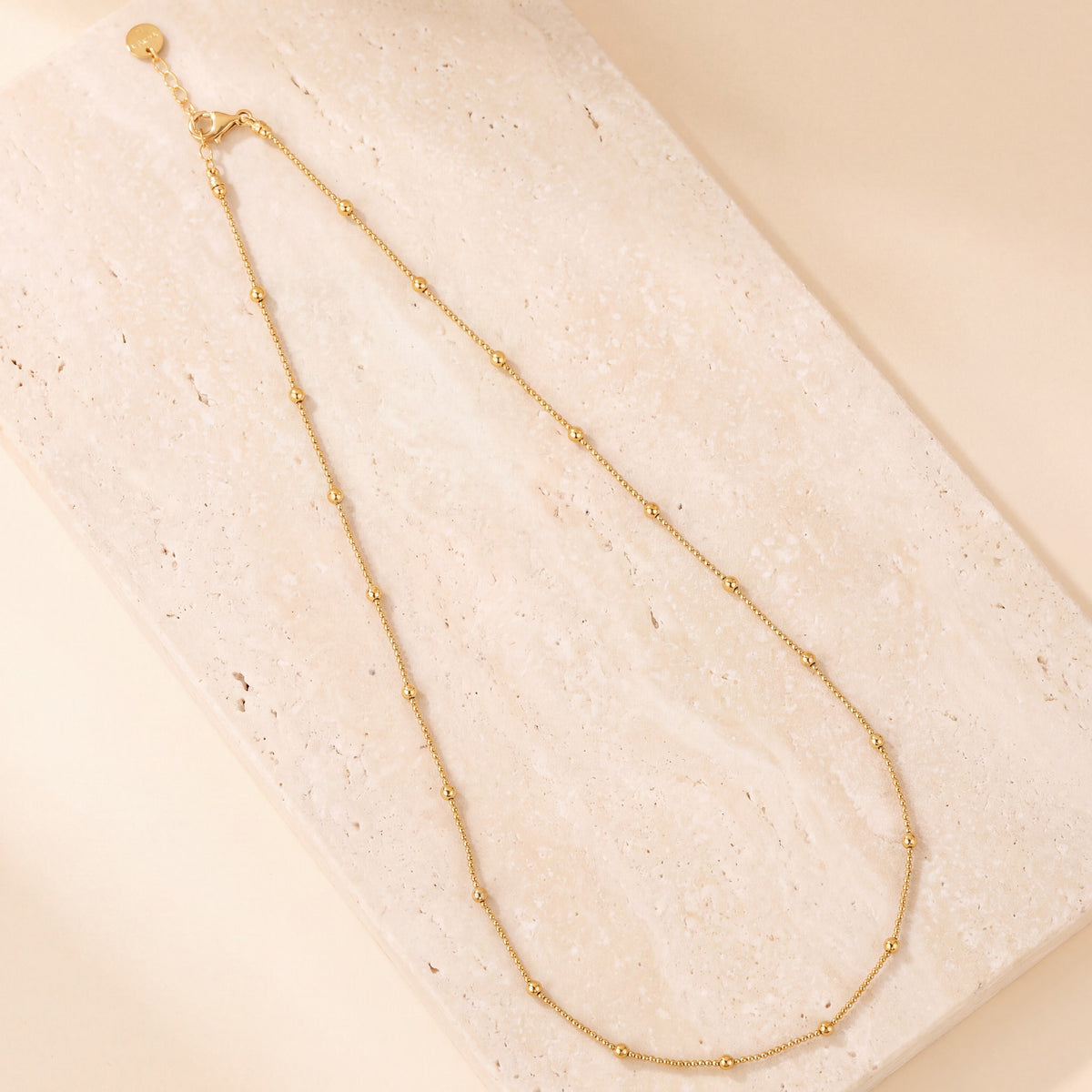 Link with Ball Chain 4 laid flat on travertine