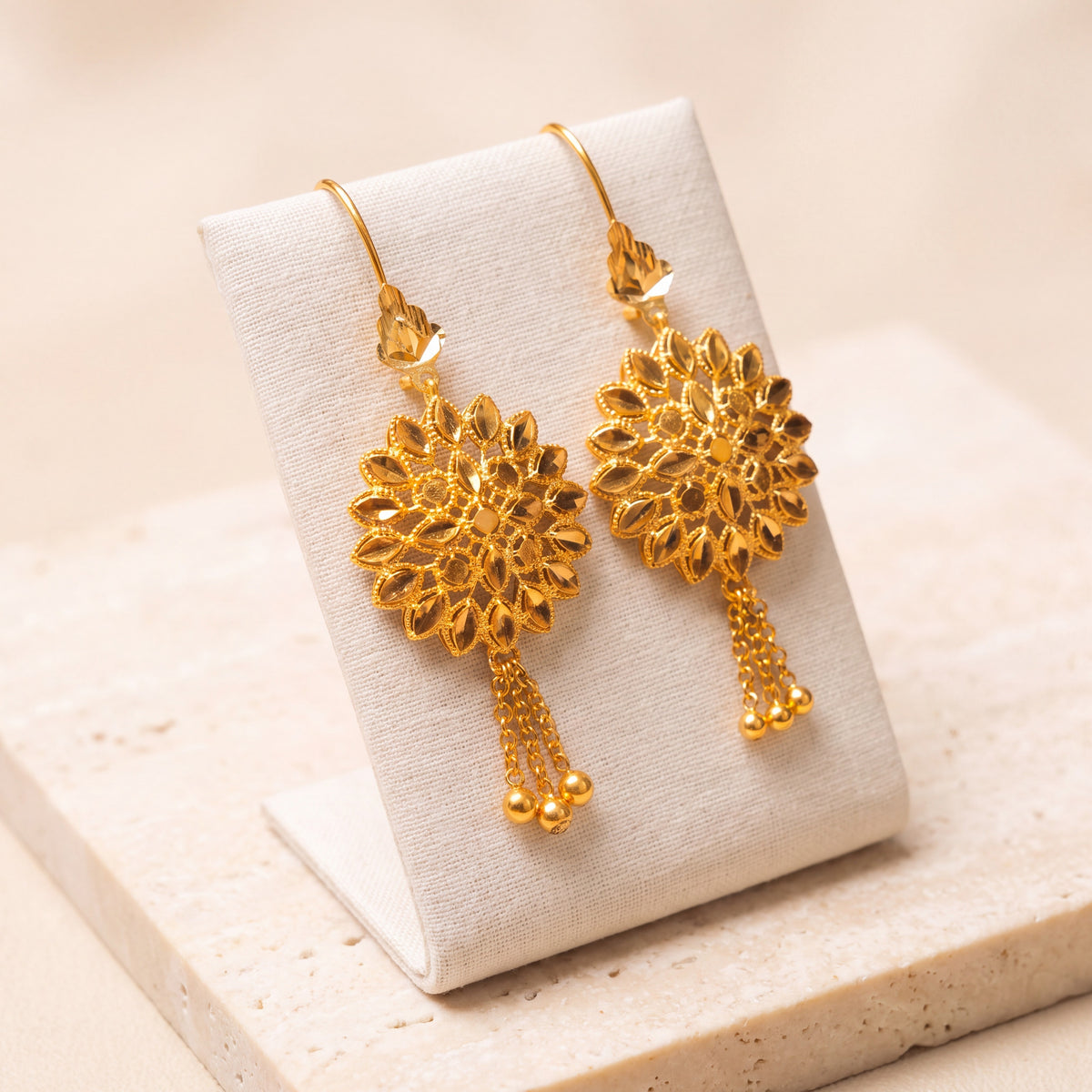 RP Earrings 5 – Gold earrings with 3 dangles, on travertine