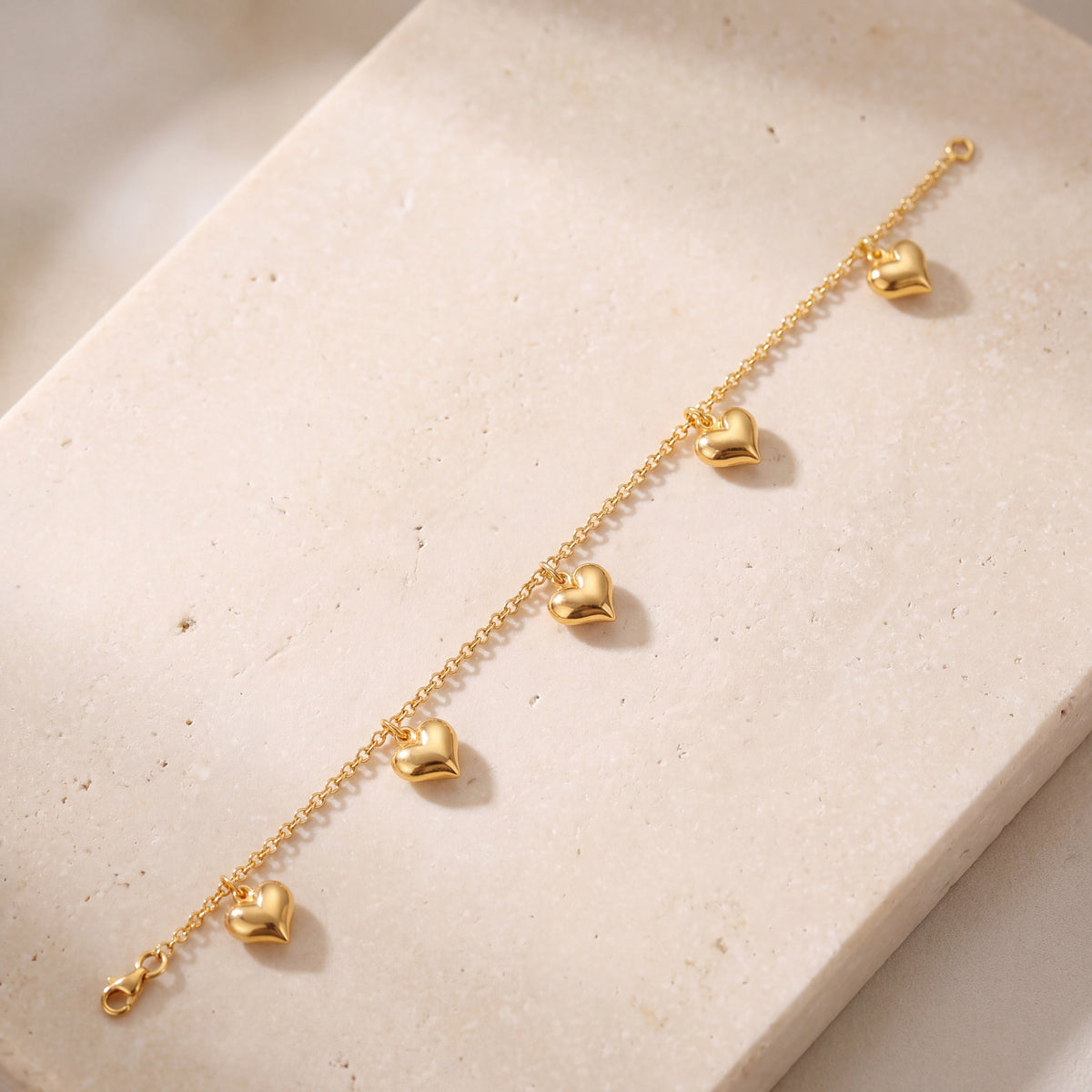 Golden Heart Charm Bracelet on travertine